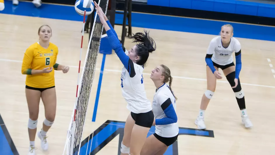 Women playing college volleyball