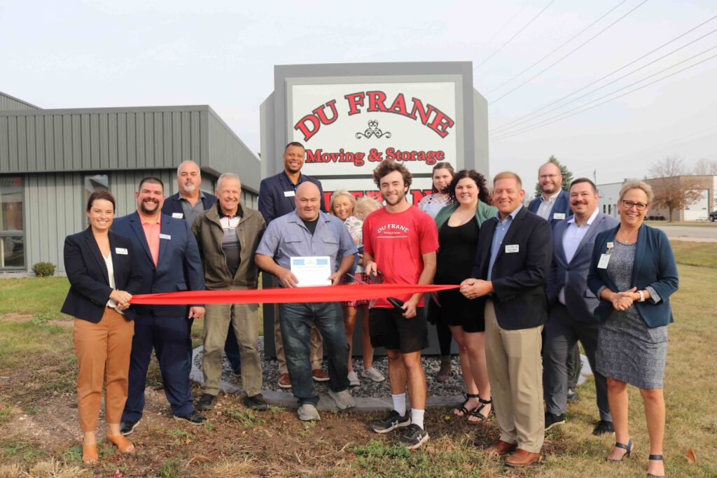 A group of people outside for a ribbon cuttin