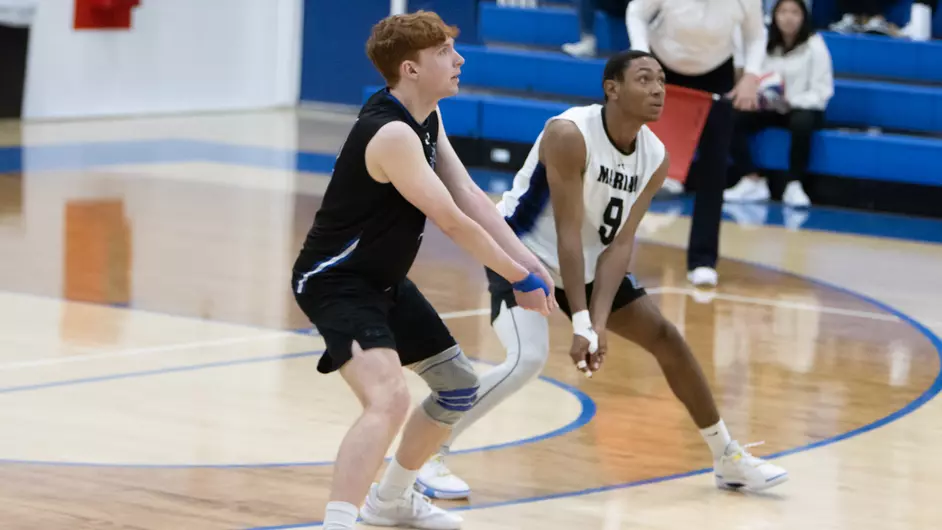 Men playing college volleyball