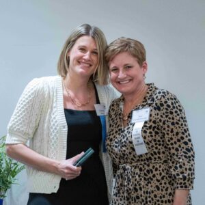 Two women, one holding an award