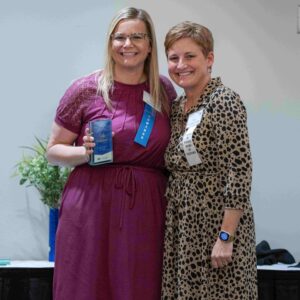  Two women, one holding an award