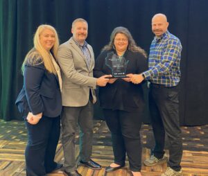 A group of four people with an award