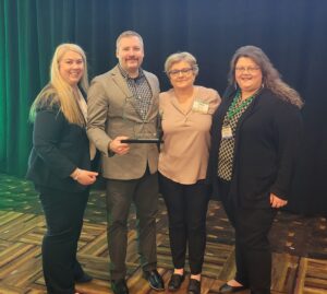 Four people with an award