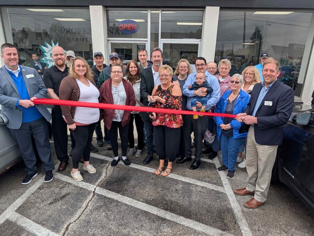 A large group of people outside for a ribbon cutting