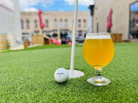 A golf ball and a glass of beer