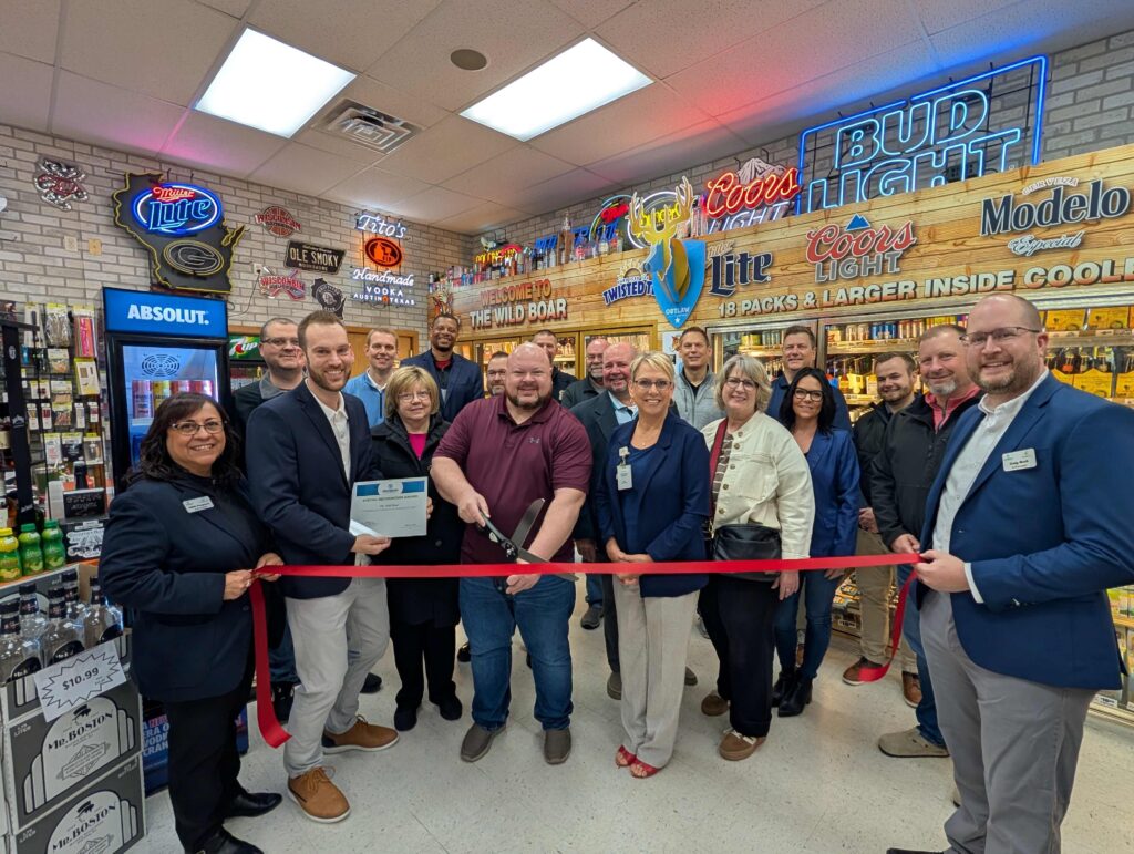 A large group inside a store for a ribbon cutting