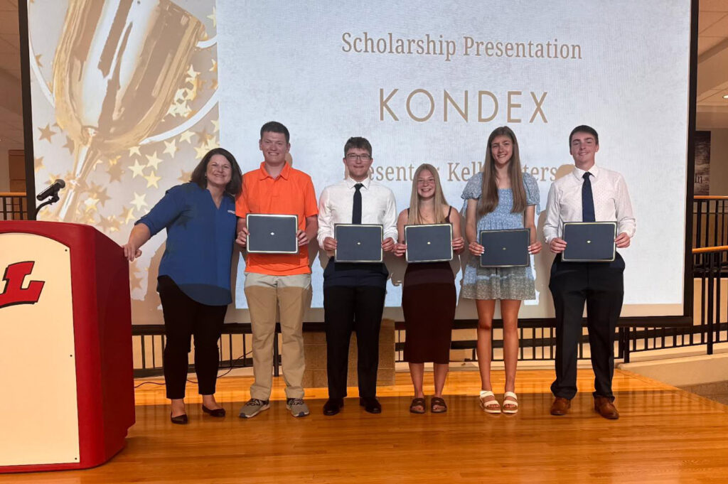 Five students and a teacher on a stage