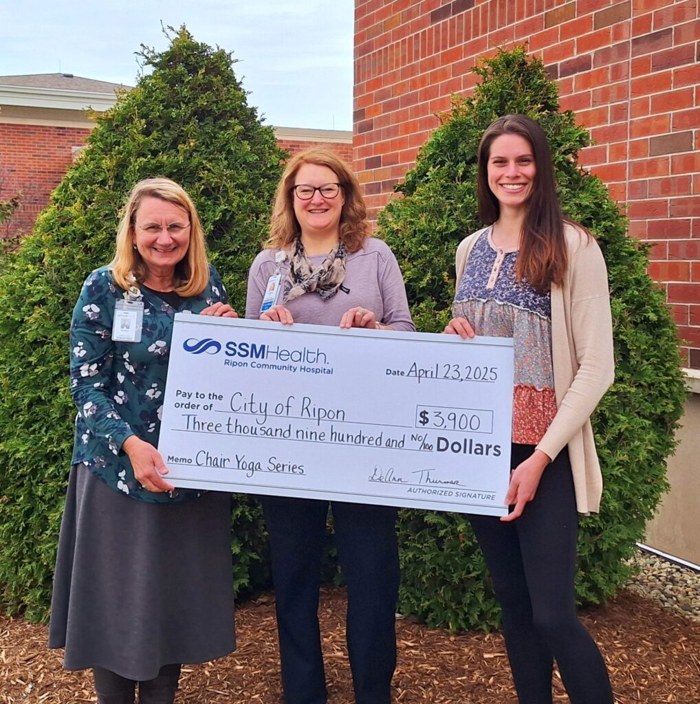 Three people with a big check