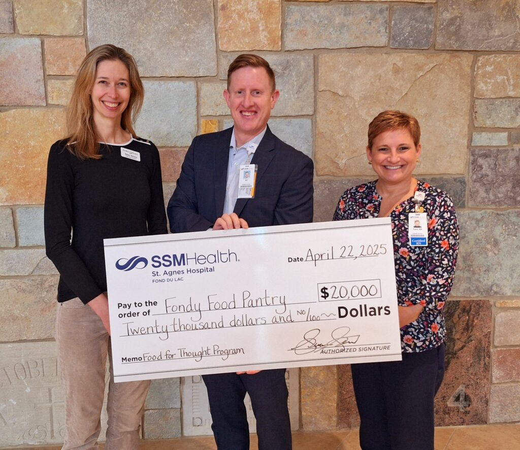 Three people holding a big check