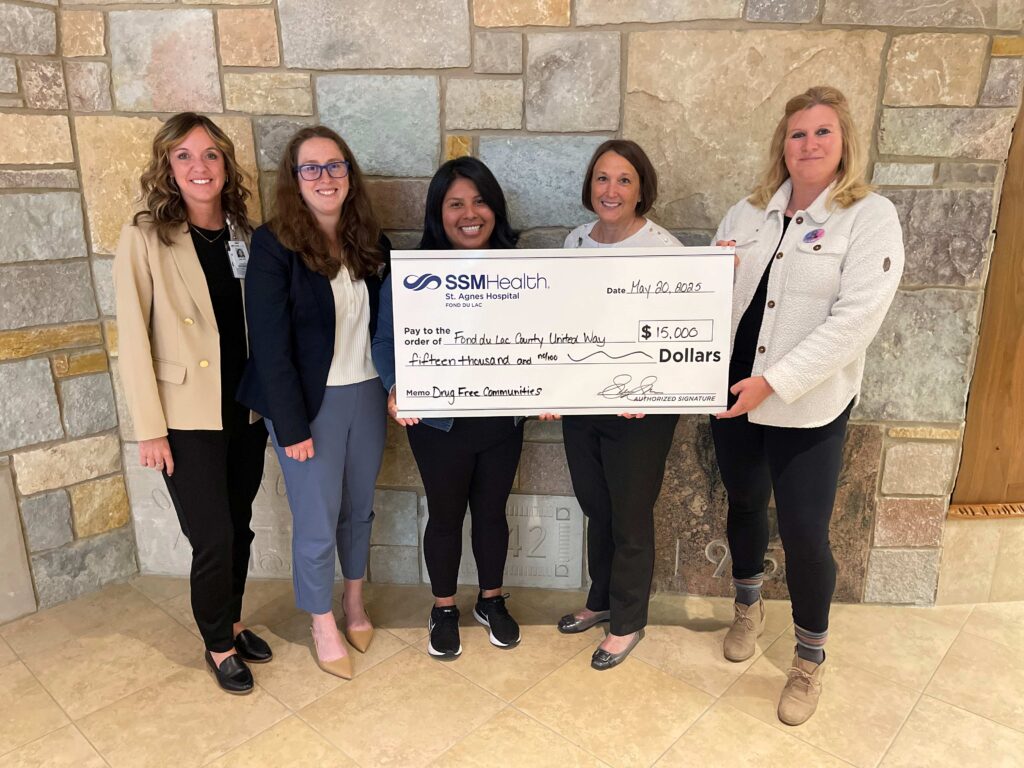 Five people with a big check