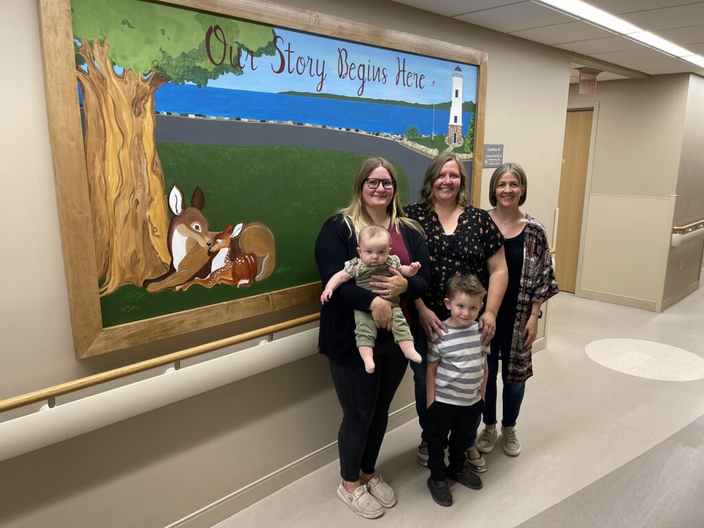 A family standing in front of a painting