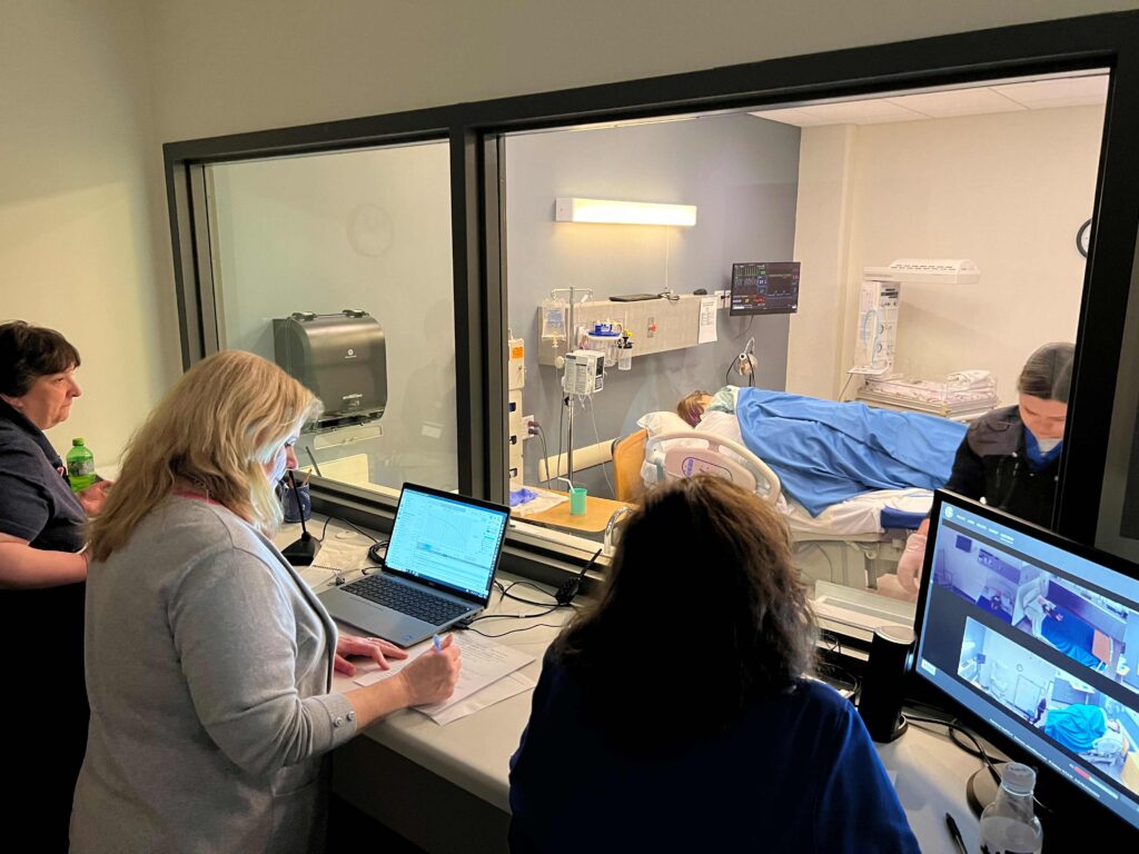 A group of people watching a medical simulation