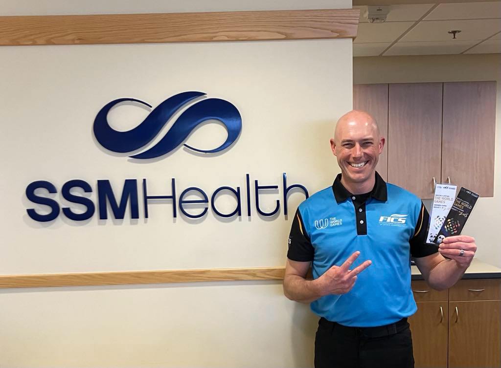 A man standing by the SSM health sign