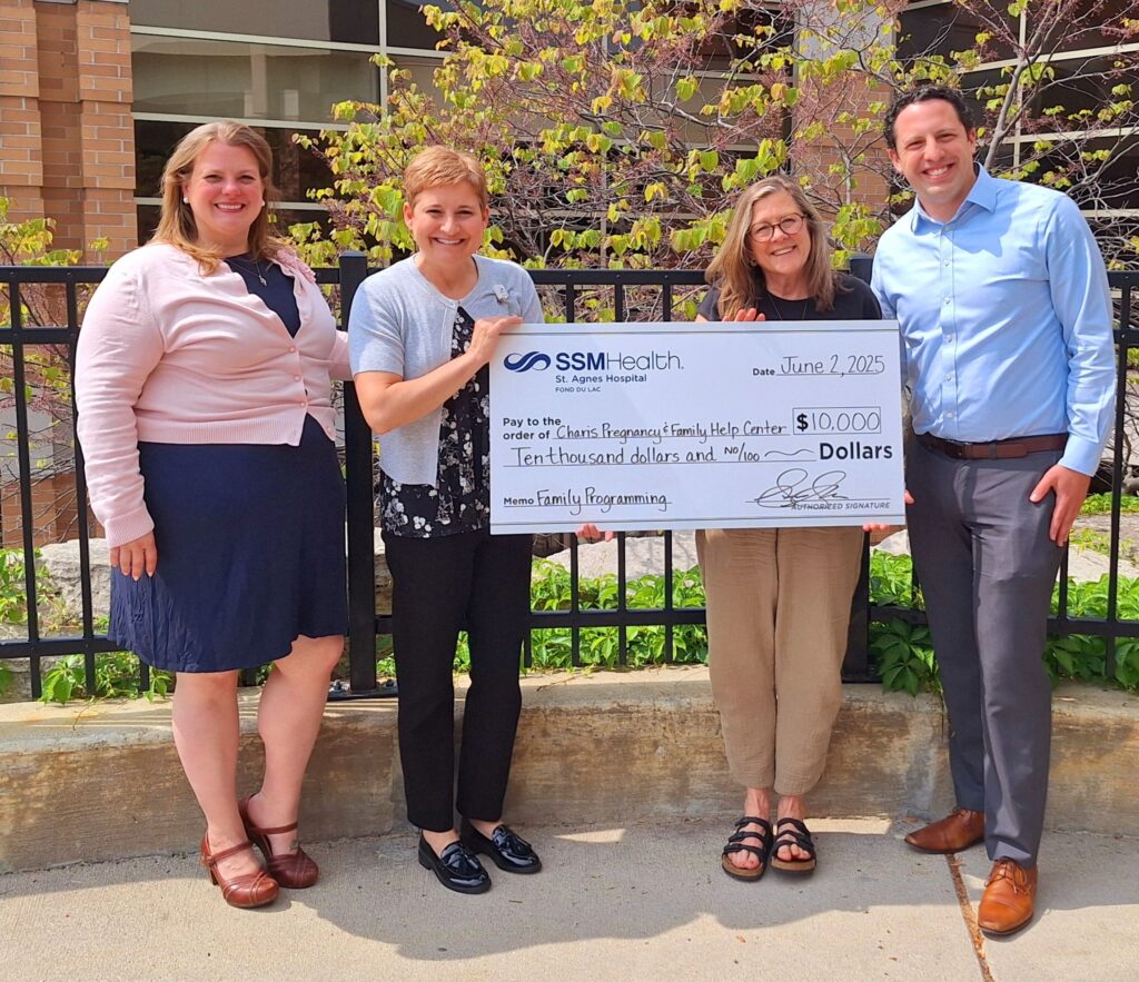 Four people holding a big check