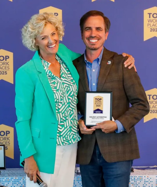 A man and a woman holding a plaque