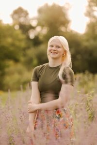 A smiling blonde girl outside