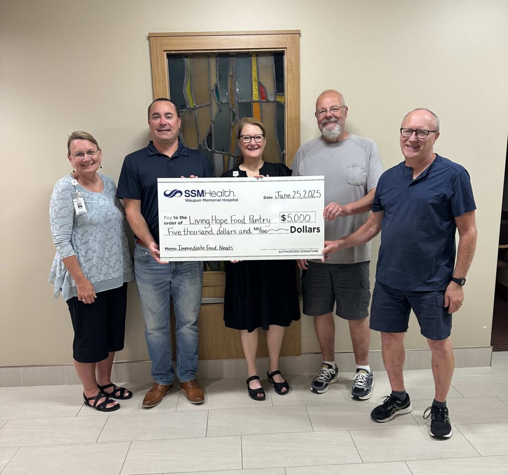 five people with a big check