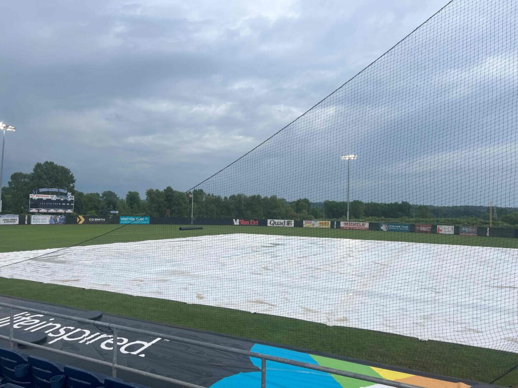 rain soaked ball field covered with a tarp