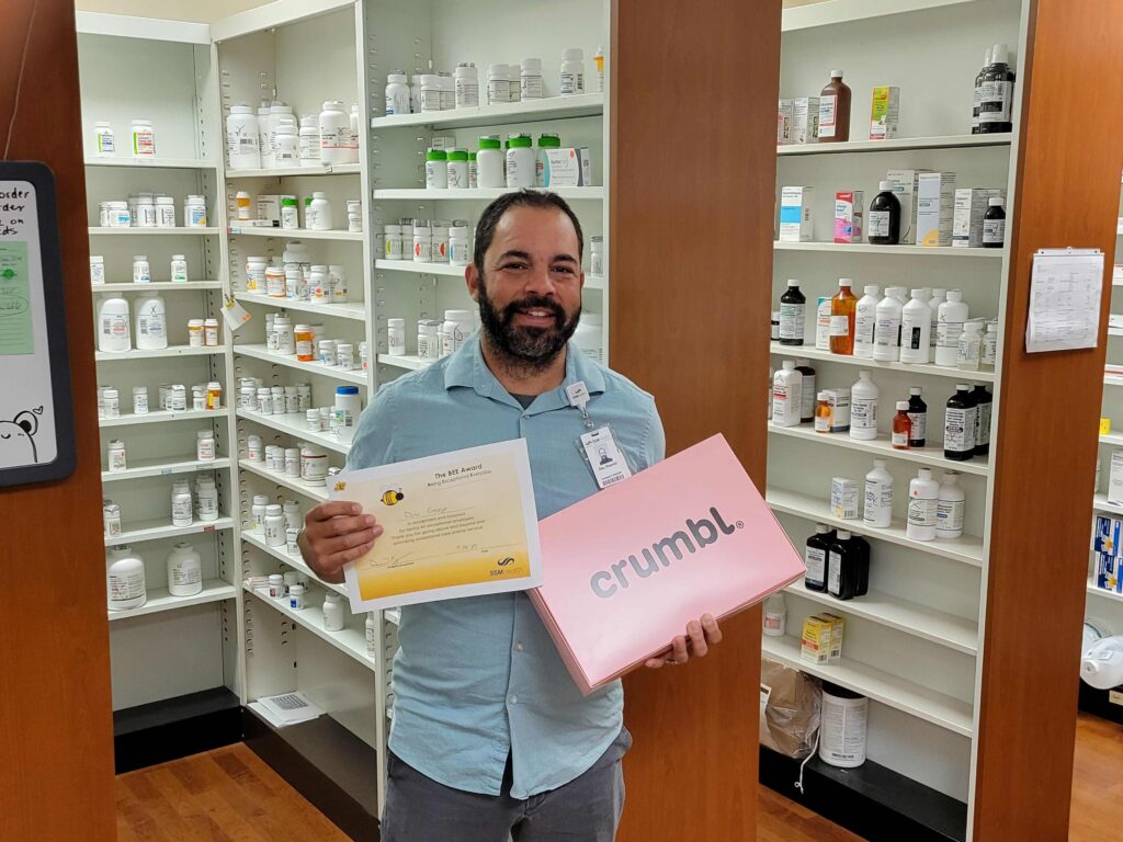 A man holding a certificate and a box of cookies