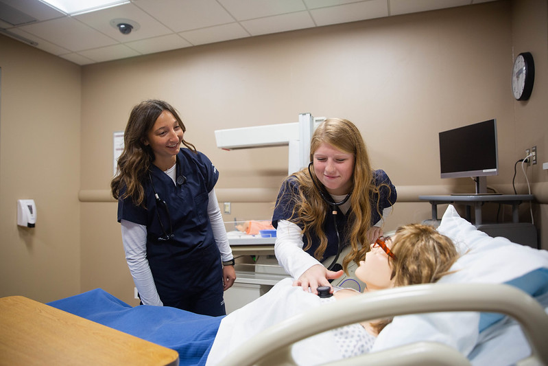 Two nursing students practing on a dummy