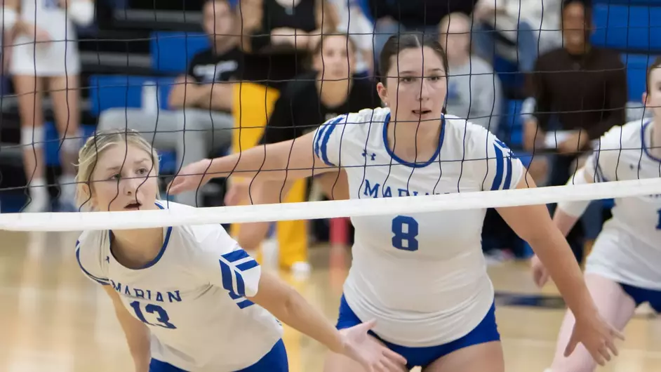 Women playing college volleyball