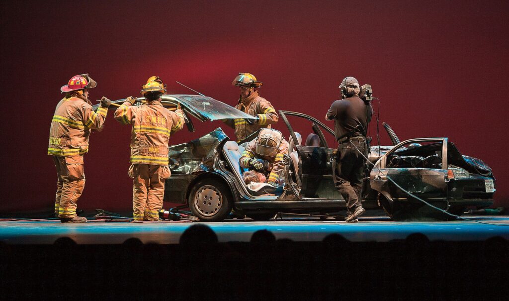 Firefighters by a wrecked car