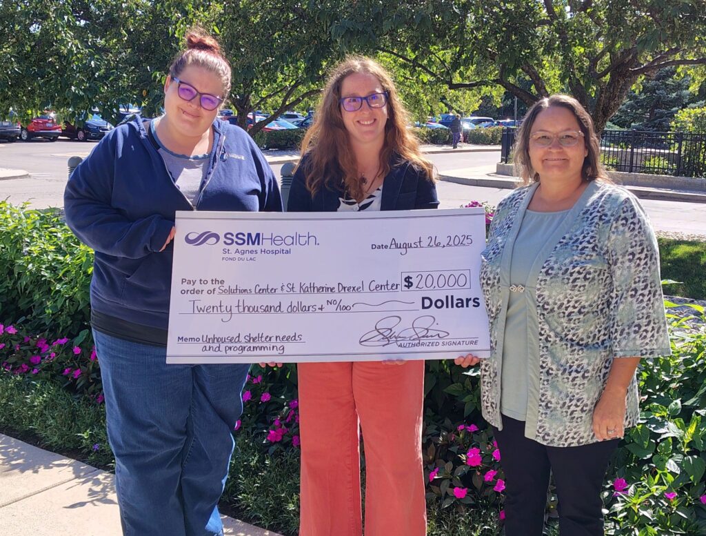 Three women holding a big check