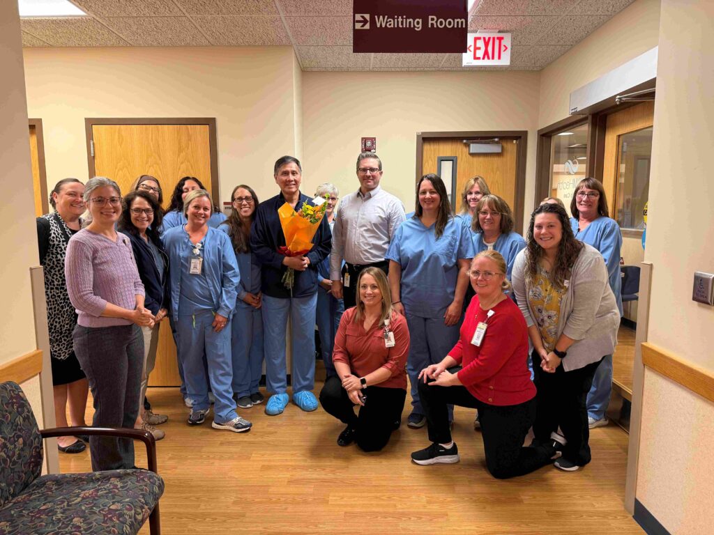A large group of medical professionals gathered around an award winner