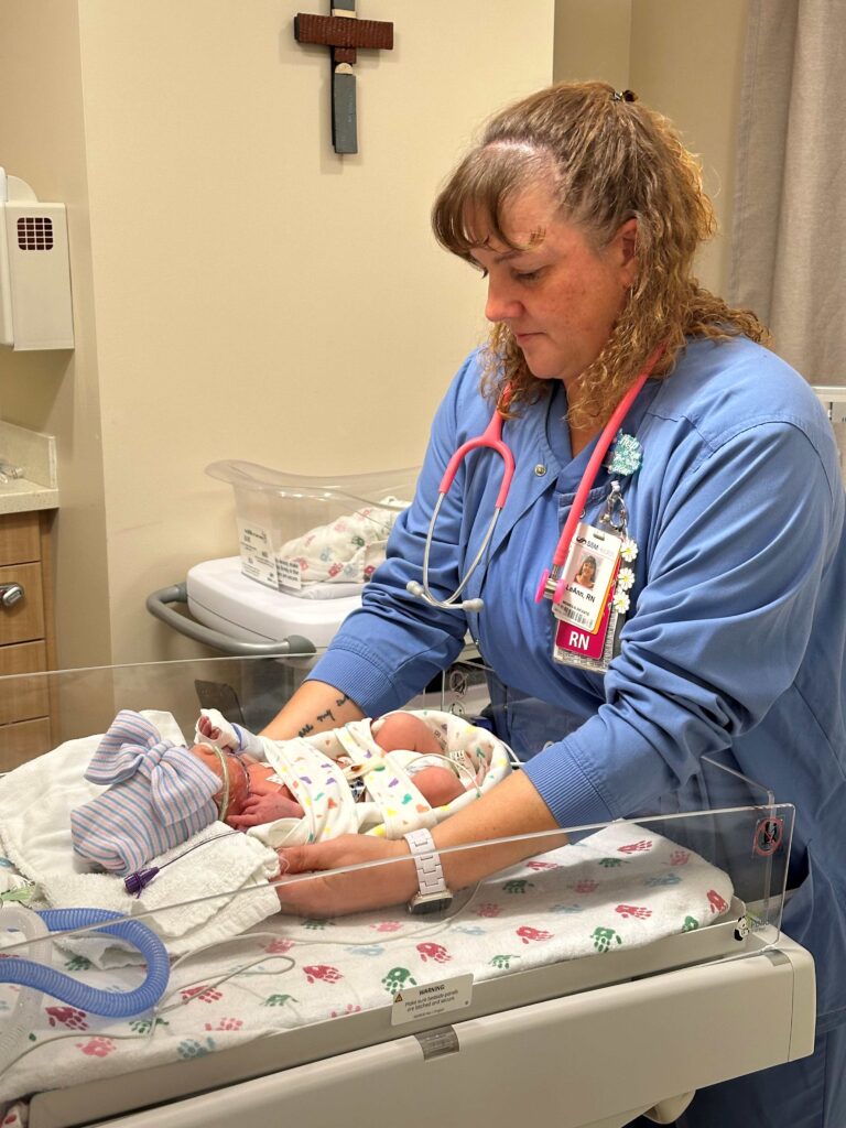 A nurse by a newborn baby