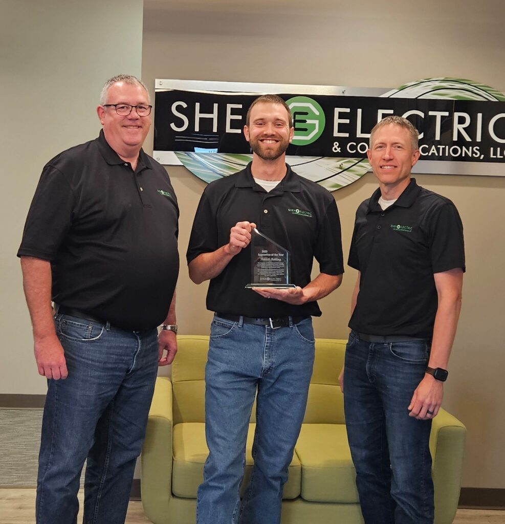Three men with one holding a trophy