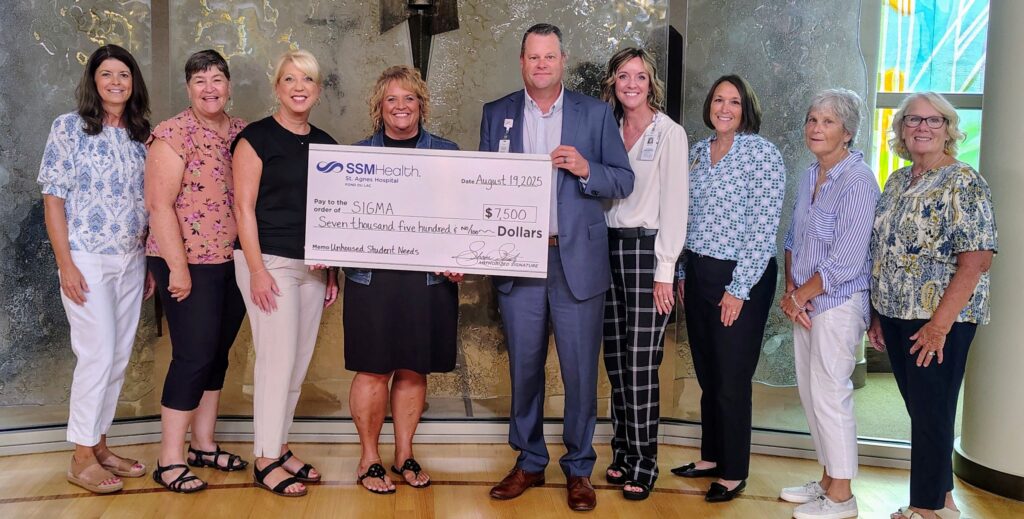 A large group of people holding a big check