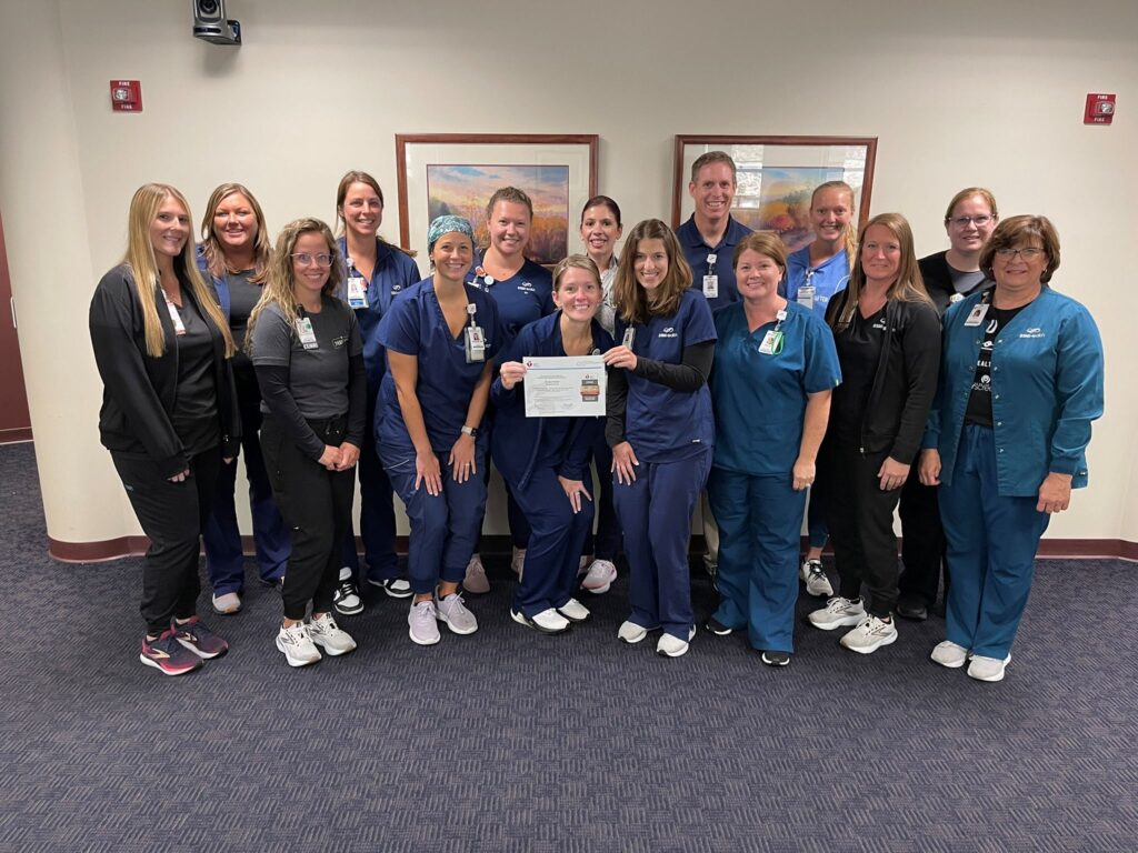 A group of medical professionals holding a certificate