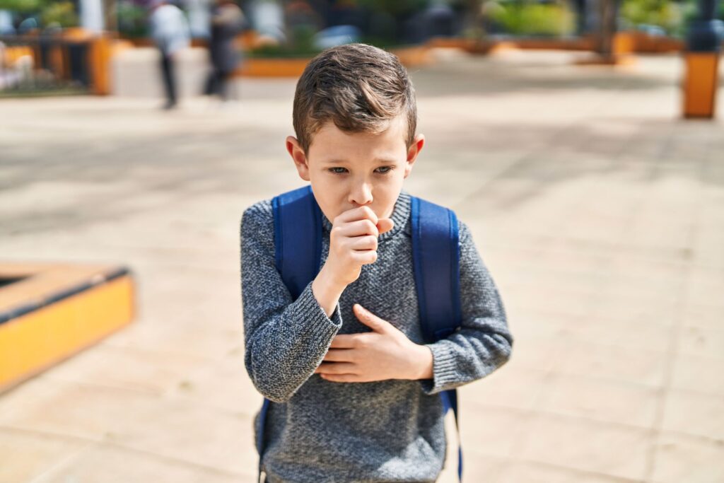 A young boy coughing