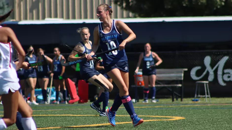 Women playing college field hockey