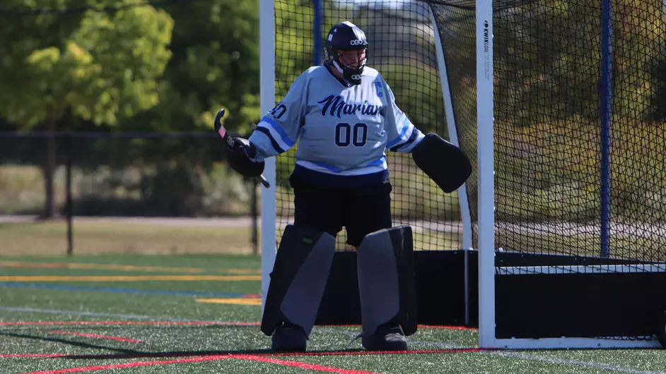 A woman playing college field hockey