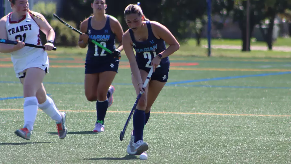 Women playing college field hockey