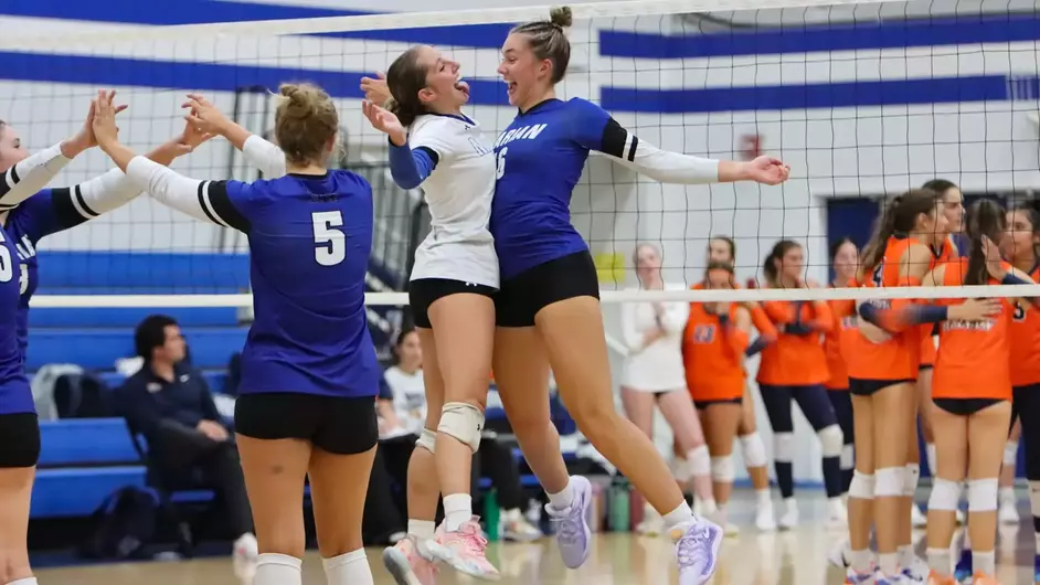Women playing college volleyball