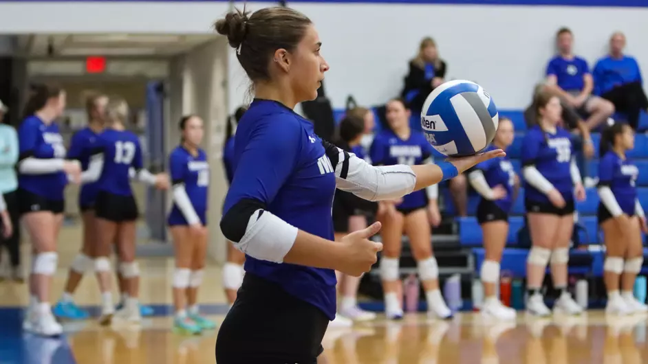 Women playing college volleyball