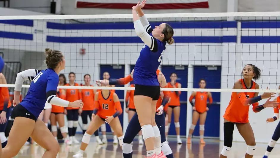 Women playing college volleyball