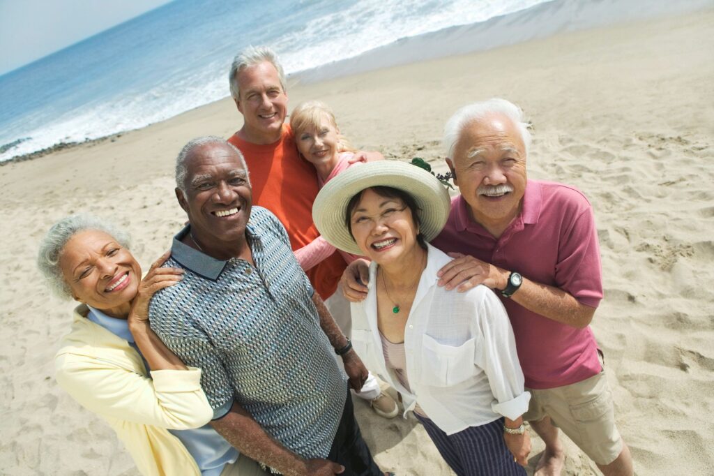 A group of older people smiling on a beach