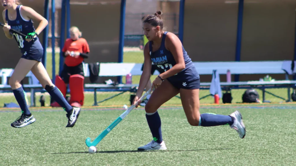 women playing college field hockey
