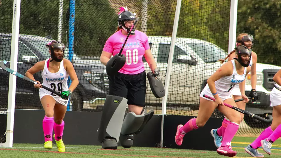 Women playing college field hockey