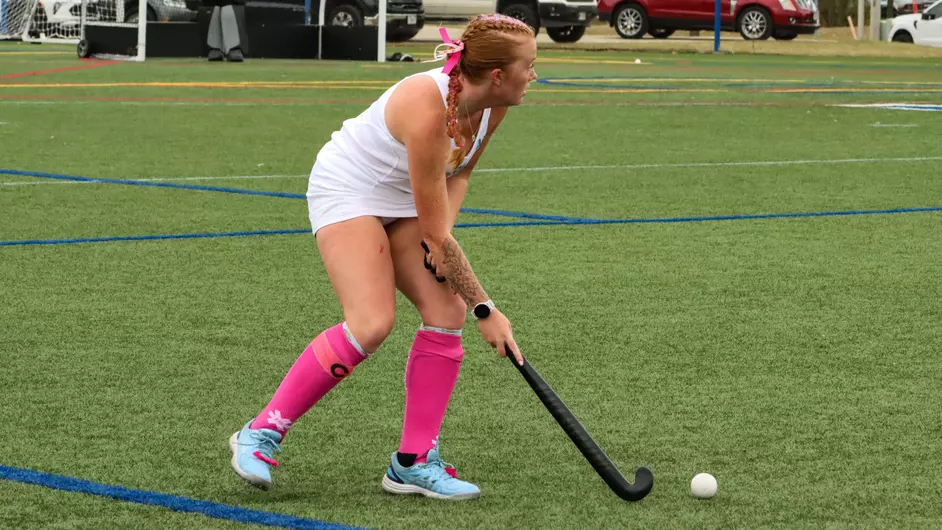 women playing college field hockey