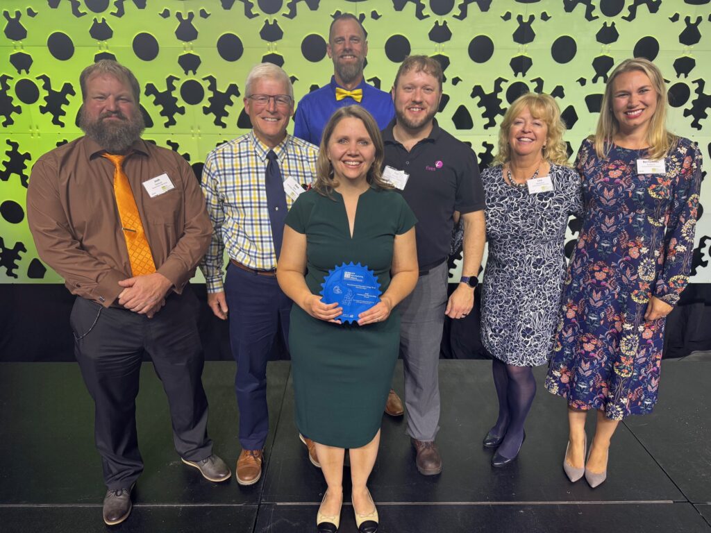 Seven people on stage with an award