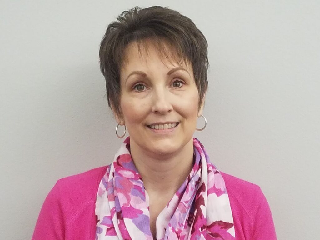 A smiling woman in pink