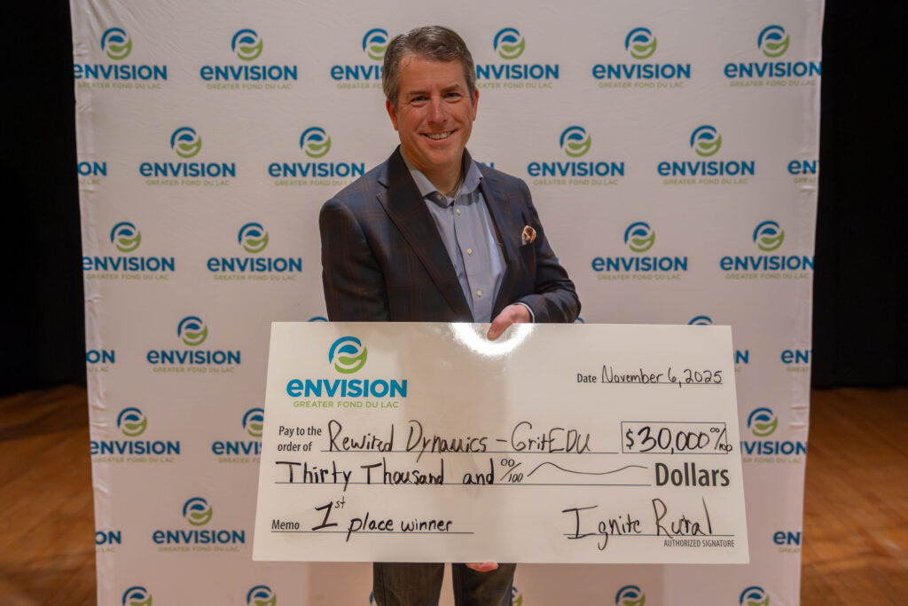 A smiling man with a big check