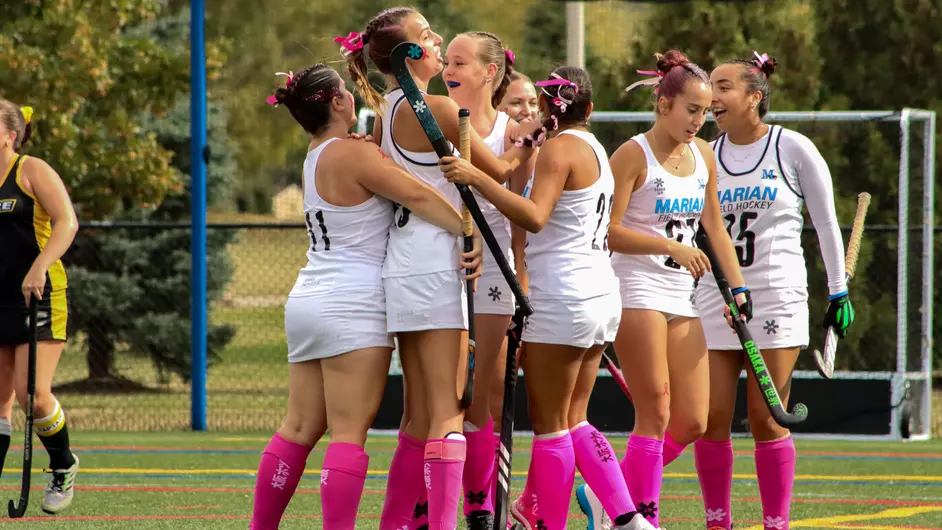 women playing college field hockey