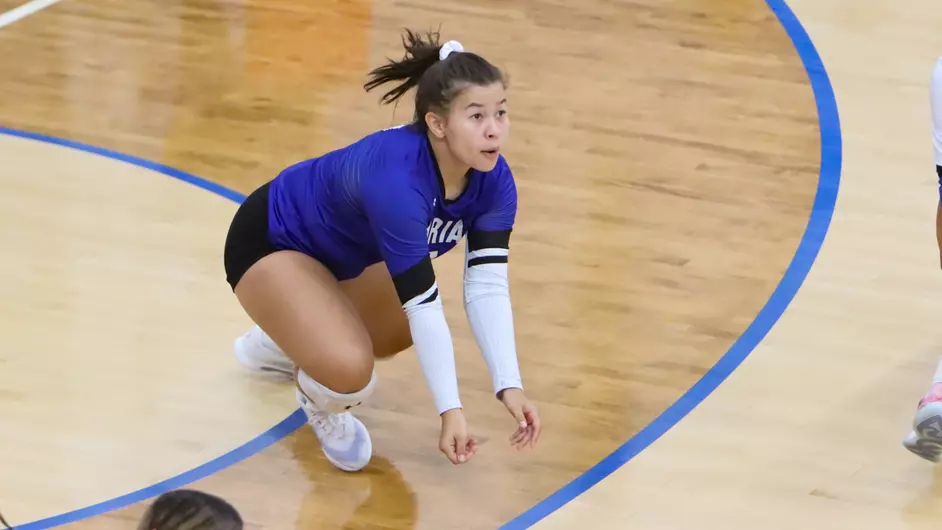 Women playing college volleyball