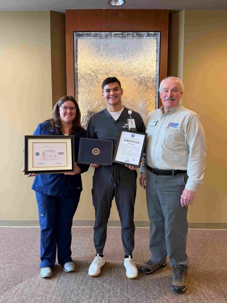 Three people with two holding awards