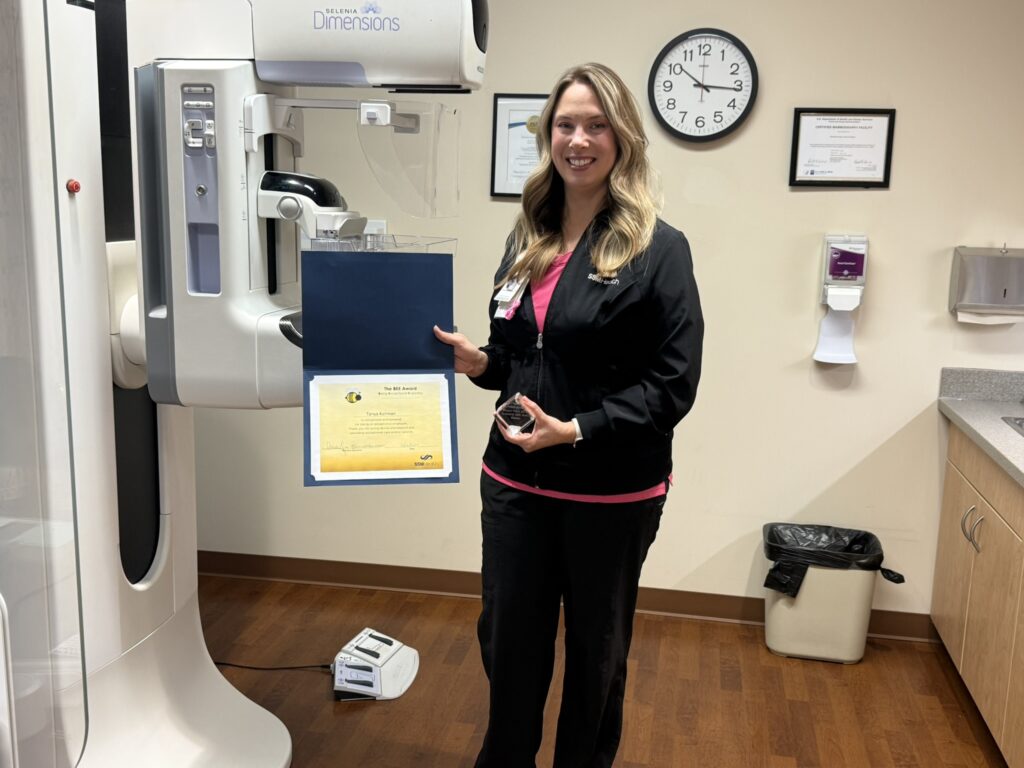 A nurse standing next to a piece of medical equipment